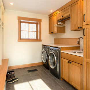 Esempio di una lavanderia multiuso rustica con lavello sottopiano, ante in stile shaker, ante in legno scuro, top in quarzo composito, paraspruzzi marrone, paraspruzzi in legno, pareti bianche, lavatrice e asciugatrice affiancate, pavimento grigio e top bianco
