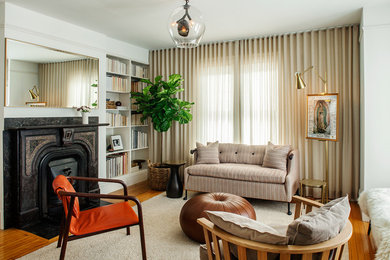 Inspiration for a transitional medium tone wood floor living room remodel in Boston with white walls and a standard fireplace