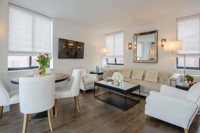 Mid-sized trendy loft-style medium tone wood floor and brown floor living room photo in New York with white walls, a wall-mounted tv and no fireplace