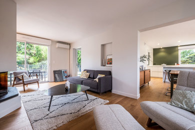 Idée de décoration pour un grand salon blanc et bois design ouvert avec un mur blanc, parquet clair, une cheminée double-face, un téléviseur indépendant et un sol marron.