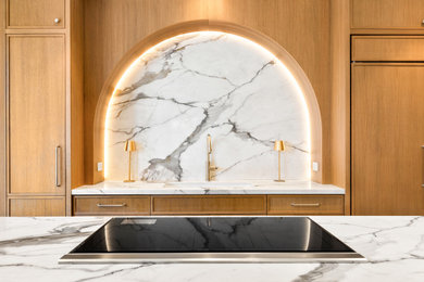 Kitchen - large transitional l-shaped ceramic tile kitchen idea in New York with an undermount sink, light wood cabinets, quartzite countertops, paneled appliances and an island