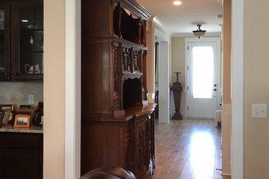 This is an example of a traditional hallway in Other with beige walls and brown floor.
