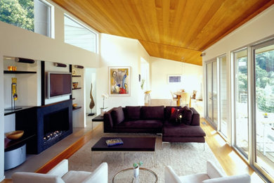 Living room - mid-sized mid-century modern open concept medium tone wood floor and brown floor living room idea in San Francisco with white walls, a standard fireplace, a tile fireplace and a wall-mounted tv