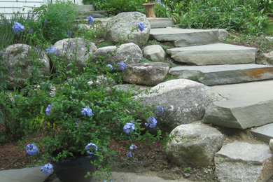 This is an example of a mid-sized country sloped garden in Calgary with a retaining wall.