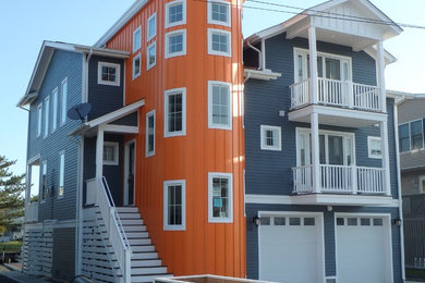 Example of a large trendy blue three-story vinyl gable roof design in Other