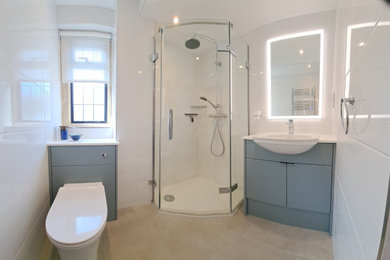 This is an example of a small modern shower room bathroom in Oxfordshire with flat-panel cabinets, green cabinets, a corner shower, a one-piece toilet, white tiles, ceramic tiles, white walls, porcelain flooring, a built-in sink, solid surface worktops, grey floors, a hinged door, white worktops, a single sink and a built in vanity unit.