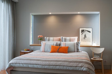 This is an example of a mid-sized contemporary master bedroom in Sydney with grey walls, medium hardwood floors and no fireplace.