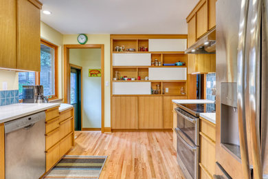 Example of a small mid-century modern light wood floor and brown floor eat-in kitchen design in Seattle with flat-panel cabinets and light wood cabinets