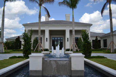 Large tropical gray two-story concrete house exterior idea in Miami with a tile roof