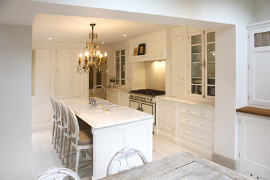 This is an example of a traditional eat-in kitchen in Surrey with with island.