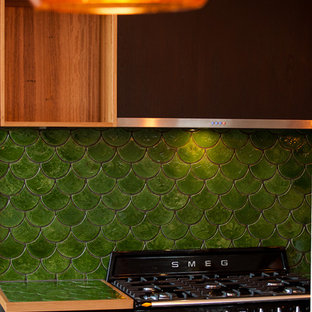 Contemporary l-shaped kitchen pantry in Adelaide with a double-bowl sink, flat-panel cabinets, black cabinets, wood benchtops, green splashback, terra-cotta splashback, stainless steel appliances, concrete floors, with island and grey floor.