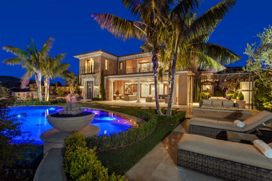 Large mediterranean multicolored two-story stone house exterior idea in Orange County with a tile roof
