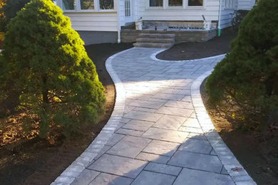 This is an example of a mid-sized front yard concrete paver landscaping in New York.