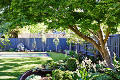 This is an example of a backyard garden in Melbourne with natural stone pavers.