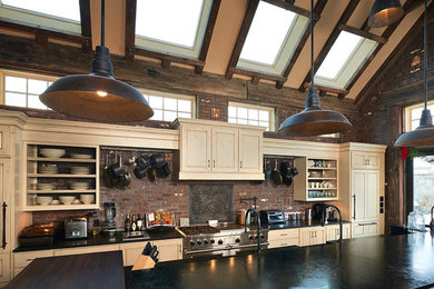 Large transitional single-wall dark wood floor and brown floor eat-in kitchen photo in Denver with raised-panel cabinets, beige cabinets, solid surface countertops, red backsplash, brick backsplash, paneled appliances and black countertops