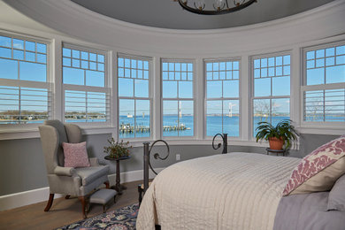 Transitional master medium tone wood floor bedroom photo in Providence with gray walls