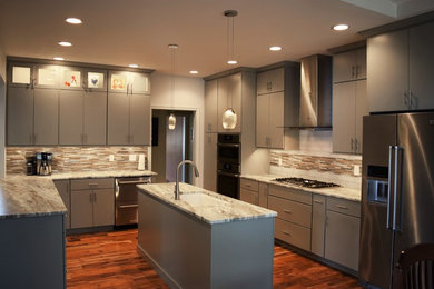 Eat-in kitchen - mid-sized contemporary u-shaped medium tone wood floor eat-in kitchen idea in Chicago with an undermount sink, flat-panel cabinets, gray cabinets, granite countertops, multicolored backsplash, mosaic tile backsplash, stainless steel appliances and an island