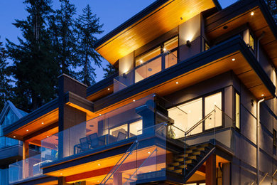 Large modern gray three-story metal exterior home idea in Vancouver with a green roof