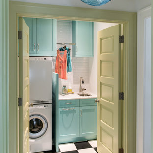 Classic single-wall separated utility room in Denver with a submerged sink, shaker cabinets, blue cabinets, white walls, a stacked washer and dryer and multi-coloured floors.