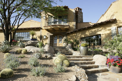 This is an example of a large front yard partial sun garden in Phoenix with natural stone pavers.