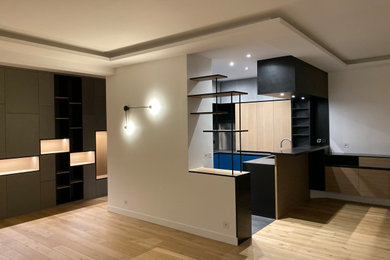 Cette photo montre une grande cuisine américaine encastrable tendance en U avec un évier intégré, un placard à porte affleurante, des portes de placard bleues, une crédence métallisée, une crédence en dalle métallique, sol en béton ciré, îlot, un sol gris et un plan de travail gris.