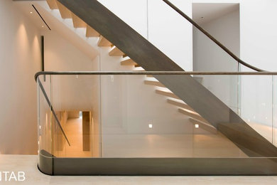 Ejemplo de escalera recta moderna de tamaño medio sin contrahuella con escalones de madera y barandilla de madera