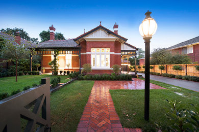 Photo of a large transitional three-storey red exterior in Melbourne with mixed siding and a gable roof.