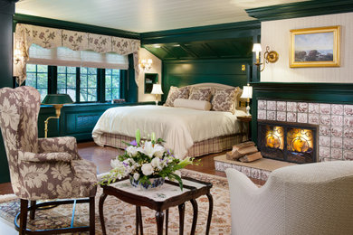 Inspiration for a large rustic medium tone wood floor bedroom remodel in Other with white walls, a corner fireplace and a tile fireplace