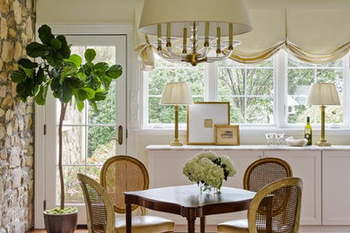 This is an example of a traditional dining room in Raleigh with yellow walls, medium hardwood floors and brown floor.