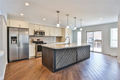 Eat-in kitchen - mid-sized transitional single-wall medium tone wood floor and brown floor eat-in kitchen idea in Other with a double-bowl sink, white cabinets, stainless steel appliances and an island