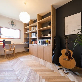 Photo of a modern home office and library in Nagoya with multi-coloured walls, medium hardwood flooring, a built-in desk and brown floors.