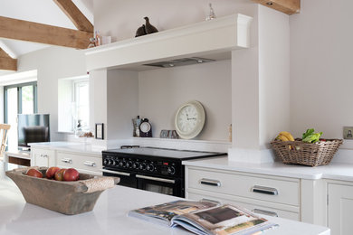 Photo of a large contemporary kitchen in Cheshire with a farmhouse sink, quartzite benchtops, porcelain floors, with island and white benchtop.