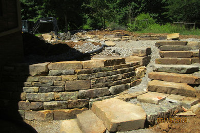 Design ideas for a huge craftsman backyard stone retaining wall landscape in St Louis.