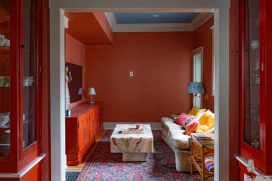 オースティンにあるシャビーシック調のおしゃれな独立型ファミリールーム (赤い壁、無垢フローリング、壁掛け型テレビ、茶色い床、折り上げ天井) の写真