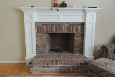 Living room - large traditional loft-style light wood floor living room idea in Boston with beige walls, a standard fireplace and a wood fireplace surround