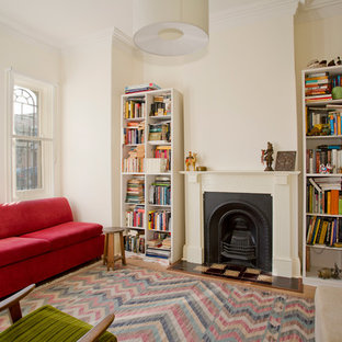 Ispirazione per un piccolo soggiorno vittoriano chiuso con libreria, camino classico, pareti bianche, parquet chiaro e cornice del camino in intonaco
