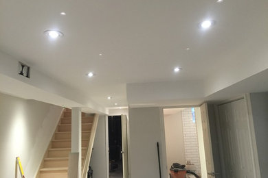 Inspiration for a mid-sized contemporary look-out concrete floor basement remodel in Toronto with white walls