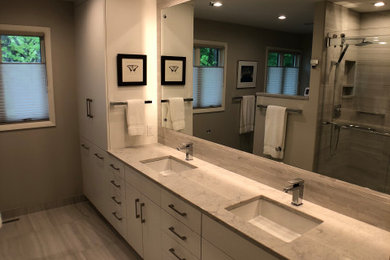 Inspiration for a contemporary master gray tile and porcelain tile porcelain tile, gray floor and double-sink bathroom remodel with flat-panel cabinets, white cabinets, a one-piece toilet, an undermount sink, quartz countertops, white countertops and a freestanding vanity