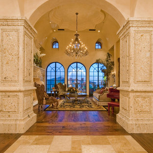 Geräumige, Abgetrennte Mediterrane Bibliothek mit beiger Wandfarbe, dunklem Holzboden, Kamin, Kaminsims aus Stein, Wand-TV und braunem Boden in Phoenix