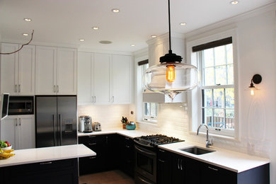 Mid-sized trendy l-shaped medium tone wood floor and brown floor eat-in kitchen photo in New York with an undermount sink, shaker cabinets, black cabinets, quartzite countertops, white backsplash, porcelain backsplash, stainless steel appliances and a peninsula