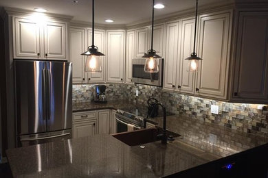 Example of a small transitional u-shaped dark wood floor and brown floor eat-in kitchen design in St Louis with a farmhouse sink, raised-panel cabinets, white cabinets, granite countertops, multicolored backsplash, glass tile backsplash, stainless steel appliances and an island
