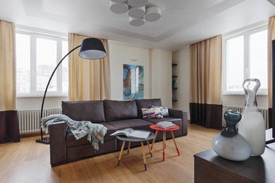 Ejemplo de salón abierto contemporáneo pequeño con paredes beige, suelo laminado, televisor independiente y suelo beige
