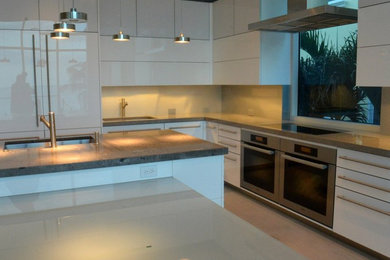 Mid-sized minimalist galley porcelain tile eat-in kitchen photo in Miami with an undermount sink, flat-panel cabinets, white cabinets, quartz countertops, gray backsplash, metal backsplash, stainless steel appliances and two islands