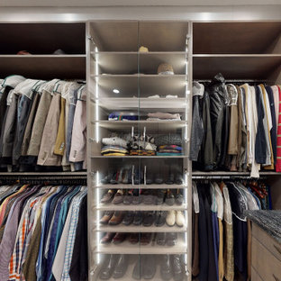 Idée de décoration pour un grand dressing minimaliste pour un homme avec un placard à porte plane, des portes de placard grises, un sol en carrelage de porcelaine, un sol beige et un plafond à caissons.