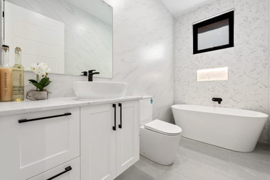 Inspiration for a small master ceramic tile, gray floor and single-sink freestanding bathtub remodel in Other with shaker cabinets, white cabinets, a one-piece toilet, a vessel sink, quartzite countertops, white countertops, a niche and a freestanding vanity