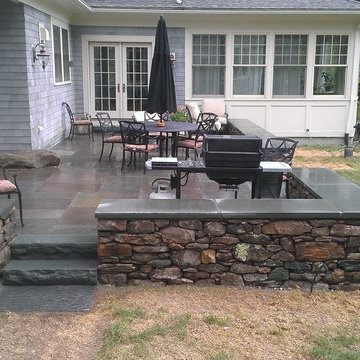 Blue stone patio and New England fieldstone capped sitting wall