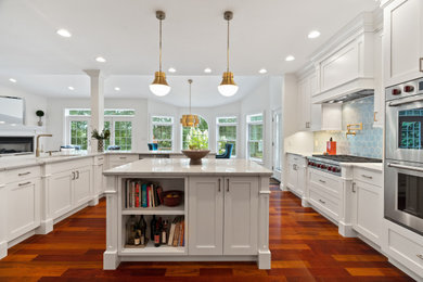 Open concept kitchen - mid-sized transitional u-shaped dark wood floor and brown floor open concept kitchen idea in Bridgeport with an undermount sink, shaker cabinets, white cabinets, quartzite countertops, blue backsplash, ceramic backsplash, stainless steel appliances, an island and white countertops