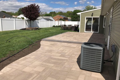 Mid-sized elegant backyard concrete paver patio photo in New York