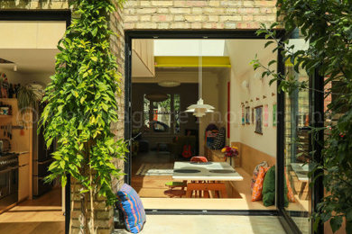 Inspiration for a medium sized contemporary back patio in London with natural stone paving.