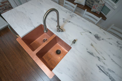 Example of a mid-sized eclectic l-shaped medium tone wood floor enclosed kitchen design in DC Metro with a farmhouse sink, beaded inset cabinets, white cabinets, quartzite countertops, blue backsplash, glass tile backsplash, stainless steel appliances and an island